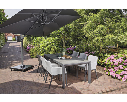 Scène de jardin avec table à manger, chaises et parasol sur une terrasse