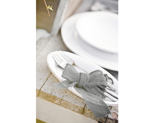 Table dressée avec assiettes, couverts et nœud en toile de jute