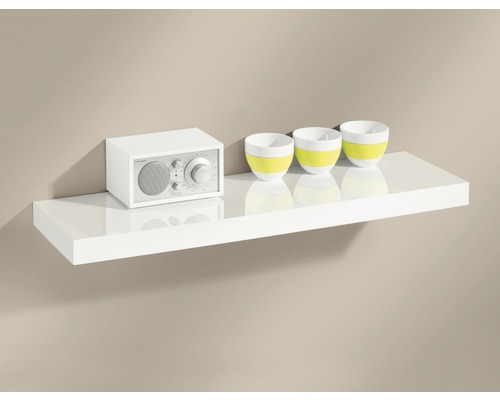 Ein weißes Wandregal mit einem Radio und drei Dekoschalen