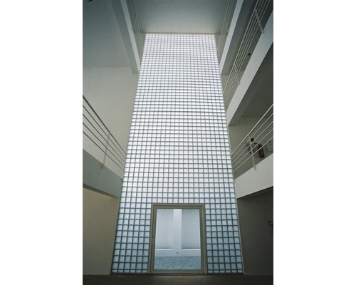 Vue intérieure d''un bâtiment avec un mur de briques de verre et une porte