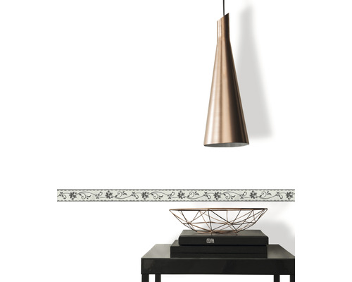 Bordure décorative à motif floral sur un mur blanc, combinée à une suspension et une table d''appoint.