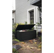 Geöffnete, schwarze Gartenbox auf einer Rasenfläche vor einem Haus