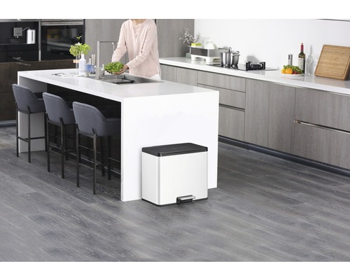 Moderne Küche mit Kücheninsel, Barhockern und einem Abfalleimer mit Pedal