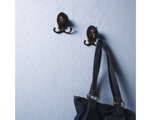 Zwei Kleiderhaken mit Tiermotiven an einer Wand, an einem der Haken hängt eine Handtasche