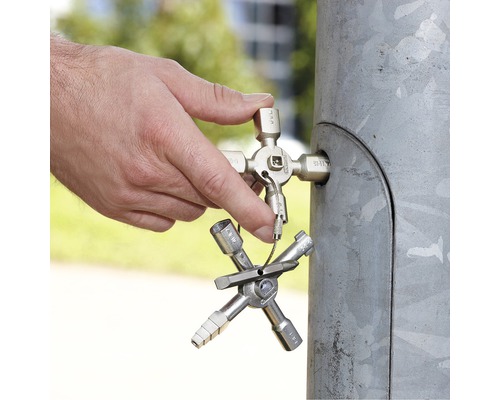 Un homme utilise une clé universelle sur une armoire de distribution.