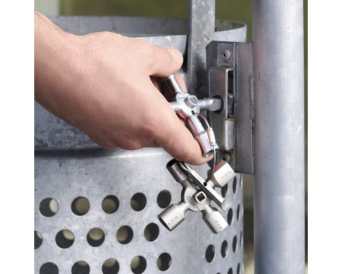 Un homme ouvre une serrure sur une poubelle avec une clé universelle.