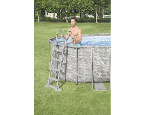 Mann steigt über eine Leiter in einen Framepool im Garten.