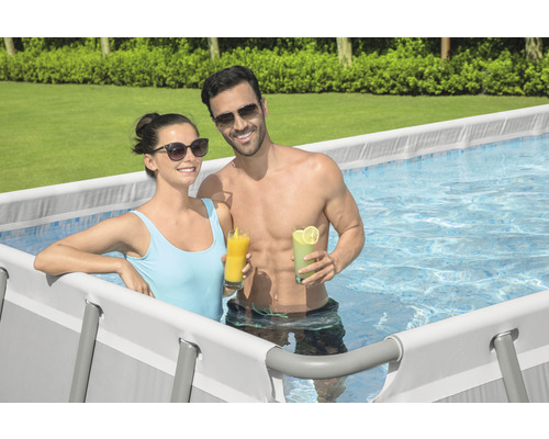 Paar entspannt mit Getränken in einem Stahlrahmenpool im Garten