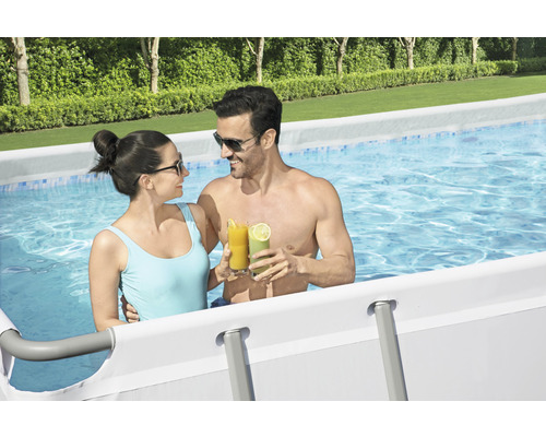 Paar mit Getränken in einem Stahlrahmenpool