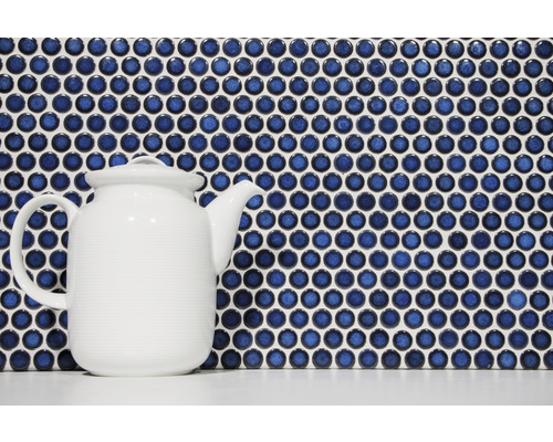 Mosaikfliesen mit runden, blauen Steinen und eine weiße Teekanne
