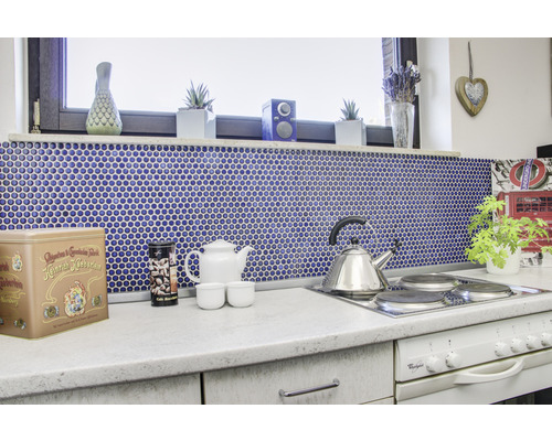 Küchenszene mit Mosaikfliesen, Teekanne und Accessoires auf der Arbeitsplatte