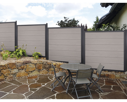 Scène de jardin avec clôture d''intimité et coin salon sur terrasse en pierre