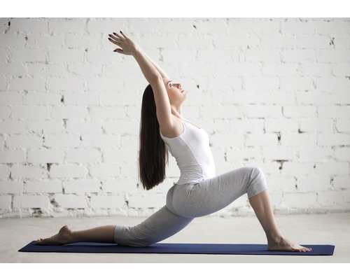 Femme en position de yoga sur un tapis de yoga