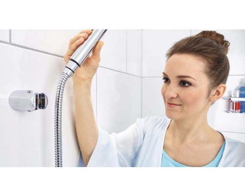 Frau mit Handbrause und Brauseschlauch in einem Badezimmer