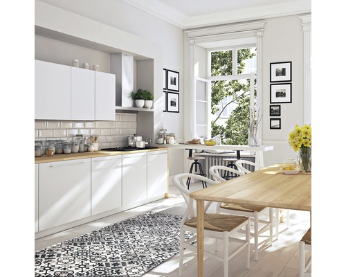 Cuisine lumineuse avec armoires blanches, plan de travail en bois, table à manger et tapis à motifs