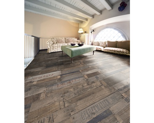 Salon avec plancher en bois à lattes avec inscriptions, canapé et table.