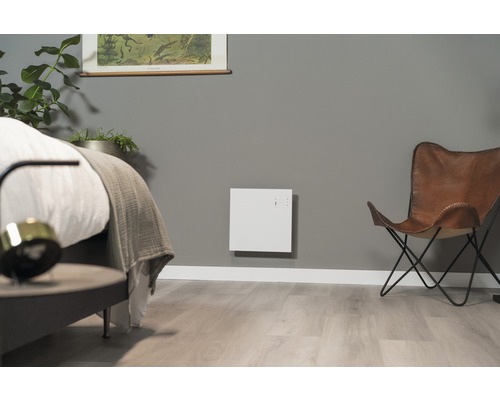 Modernes Schlafzimmer mit Heizkörper, Bett und Sessel