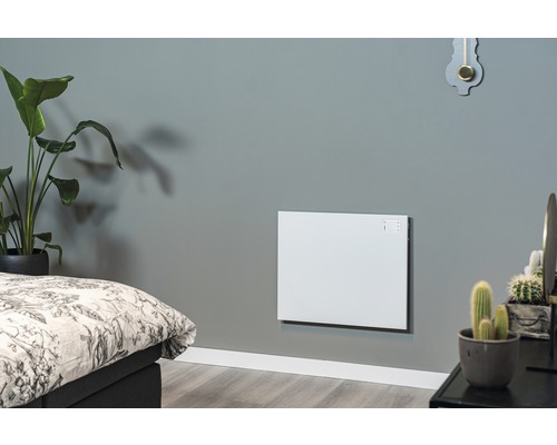 Wohnraum mit montierter, weißer Wandheizung neben einem Bett und Pflanzen