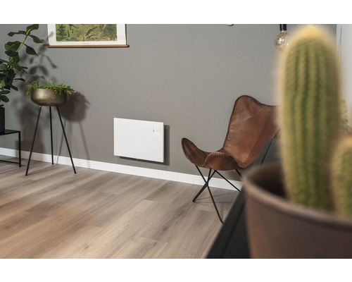 Wohnzimmer mit Elektroheizung an der Wand und Ledersessel