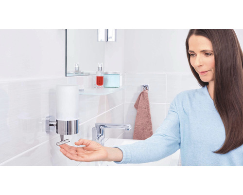 Frau benutzt Seifenspender im Badezimmer