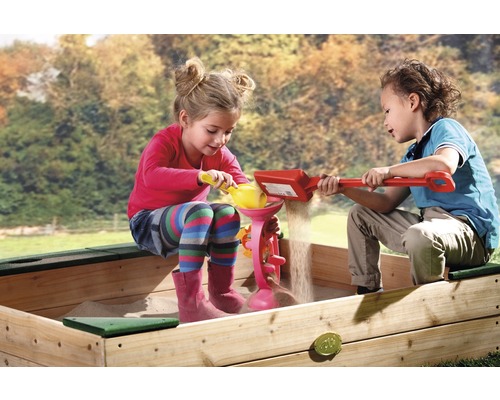 Zwei Kinder spielen mit Sand in einem Sandkasten mit Sandspielzeug
