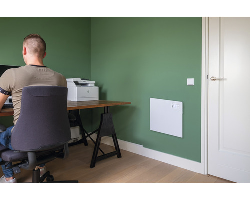 Büro mit Heizpaneel an der Wand, Schreibtisch und Bürostuhl.