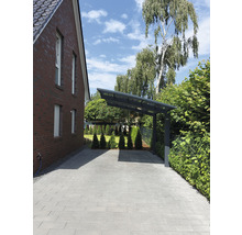 Allée avec pavés et abri de voiture à côté d''une maison en briques