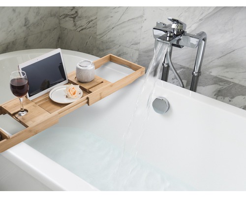 Scène d''une baignoire remplie avec tablette de baignoire extensible, tablette, verre de vin, pot en céramique et fleur