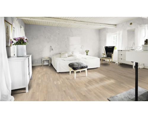 Heller Schlafzimmerraum mit Holzboden, Bett und weißen Möbeln.