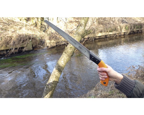 Fiskars Handsäge beim Sägen eines Astes im Freien