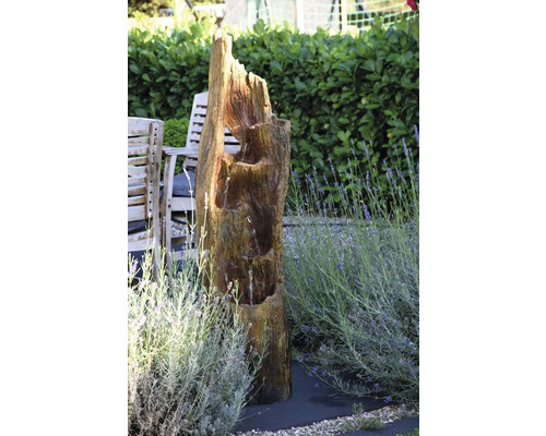 Scène de jardin avec fontaine en tronc d''arbre, mobilier de jardin et lavande