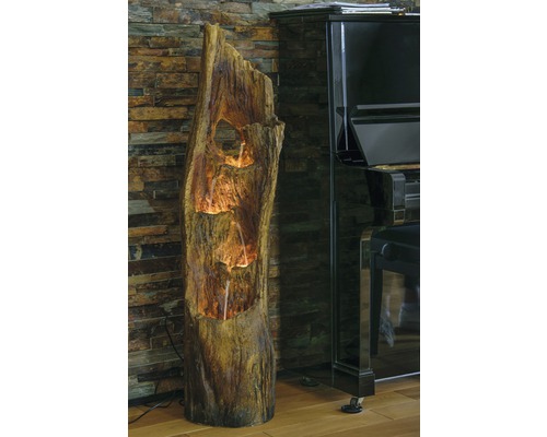 Fontaine d''intérieur décorative aspect tronc d''arbre à côté d''un piano