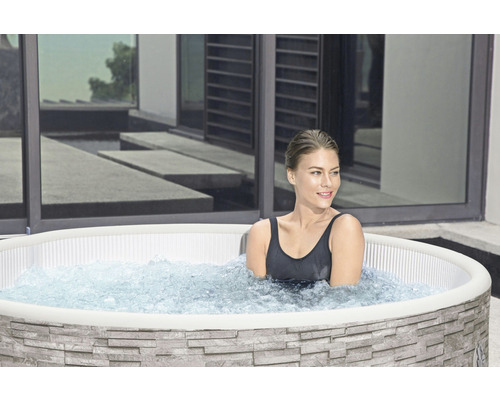 Frau in aufblasbarem Whirlpool mit Steinoptik