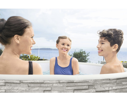 Familie entspannt in einem aufblasbaren Whirlpool mit Steinoptik