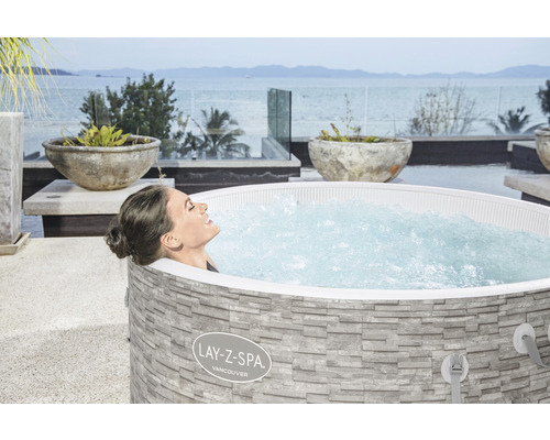 Frau entspannt im Lay-Z-Spa Vancouver Whirlpool auf einer Terrasse mit Meerblick