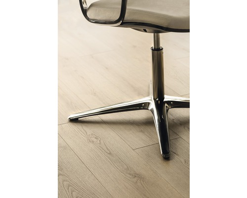 Detailansicht eines Bürostuhls mit Chromfuß auf einem Holzboden