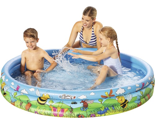 Piscine gonflable pour enfants avec des enfants et des adultes qui jouent dans le jardin