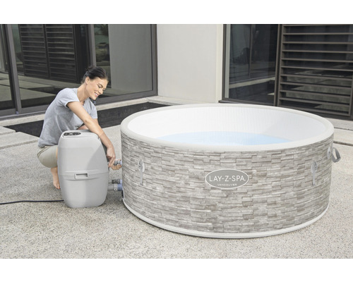 Frau schliesst Lay-Z-Spa Vancouver Whirlpool an die Pumpe im Aussenbereich an