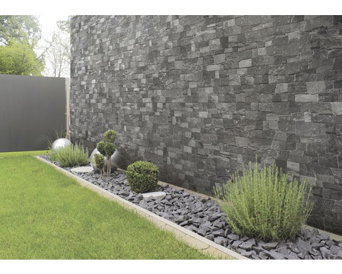 Jardin avec parement mural en pierre, gravier décoratif et plantes