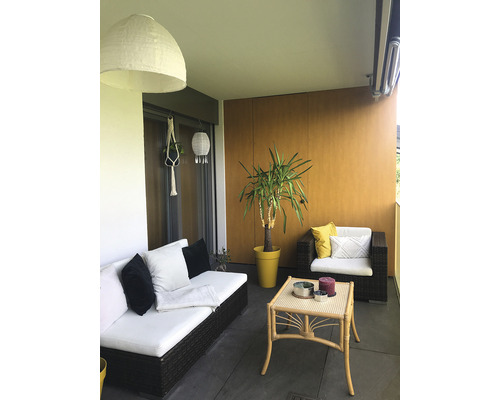 Balkon mit Rattansofa, Sessel, Tisch, Pflanze und Dekoration