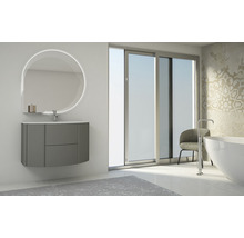 Salle de bain avec meuble-lavabo, miroir lumineux et baignoire devant une fenêtre