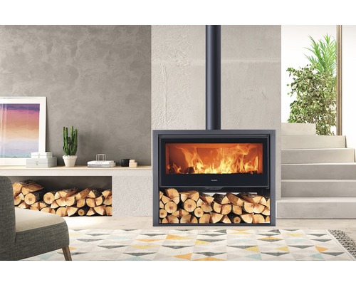 Kaminofen mit Holzscheiten und brennendem Feuer im Wohnzimmer