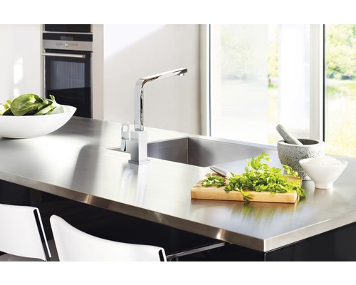 Moderne Küche mit Edelstahlspüle, Armatur, Kräutern und Schüssel