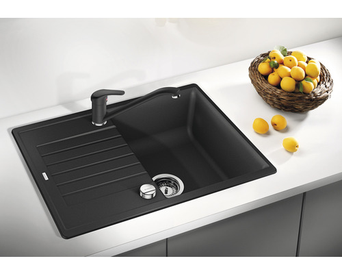 Schwarze Küchenspüle mit Abtropffläche und Armatur auf einer Küchentheke