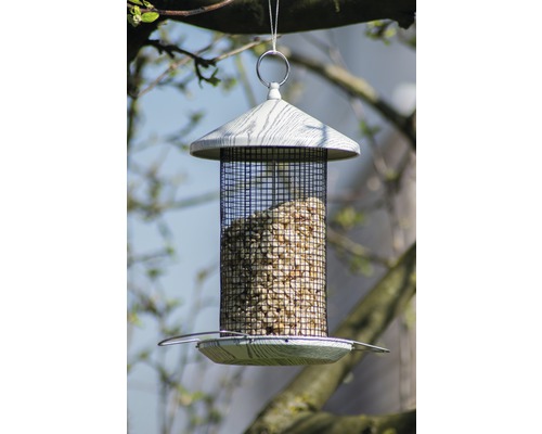 Mangeoire à oiseaux avec filet à nourriture rempli, suspendue à un arbre.