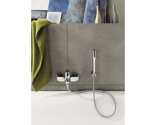 Robinet de baignoire apparent avec douchette à main et serviette sur la baignoire