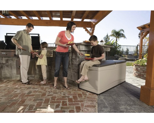 Famille faisant un barbecue dans le jardin avec un coffre de rangement servant de siège