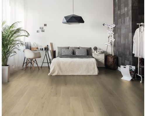 Heller Schlafzimmerraum mit Bett, Schreibtisch, Pflanze und hellem Holzboden