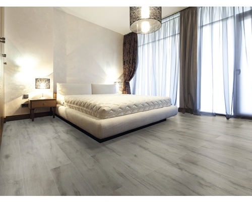 Schlafzimmer mit Bett, Nachttisch und hellem Holzboden