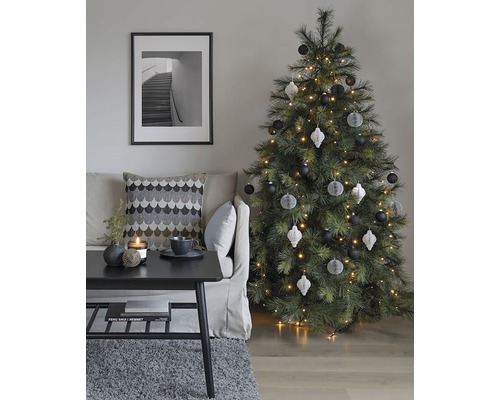 Salon décoratif avec sapin de Noël, canapé, table et image encadrée